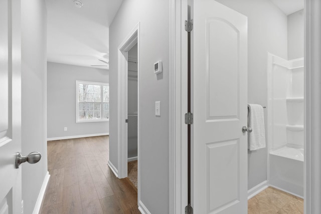 hallway with baseboards and wood finished floors