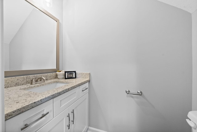 half bath with toilet, vanity, and baseboards