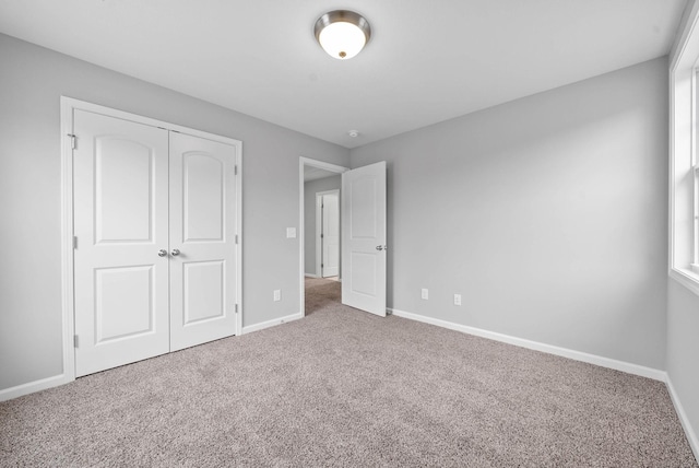 unfurnished bedroom with a closet, baseboards, and carpet floors