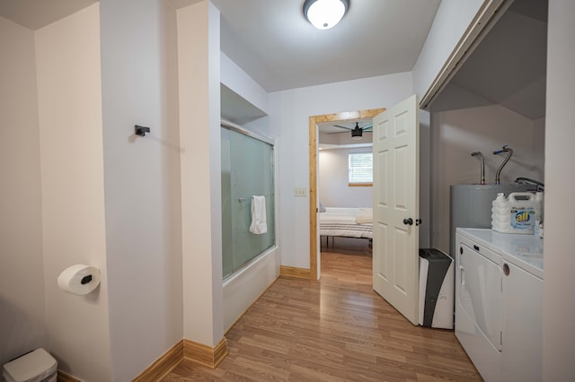 ensuite bathroom with shower / bath combination with glass door, ensuite bath, wood finished floors, vanity, and washing machine and dryer