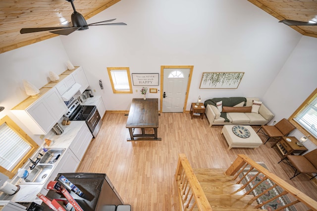 living area with light wood-type flooring, wood ceiling, high vaulted ceiling, and ceiling fan