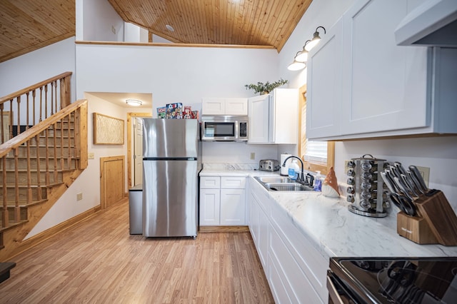 kitchen with appliances with stainless steel finishes, white cabinetry, light wood-type flooring, wooden ceiling, and exhaust hood