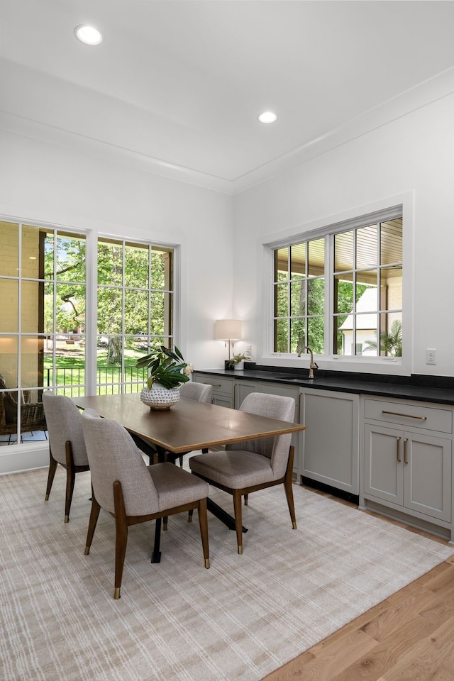 dining space featuring a healthy amount of sunlight, light hardwood / wood-style flooring, and crown molding