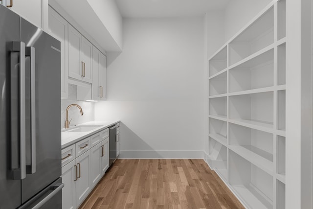 kitchen featuring sink, white cabinets, light hardwood / wood-style flooring, and stainless steel appliances