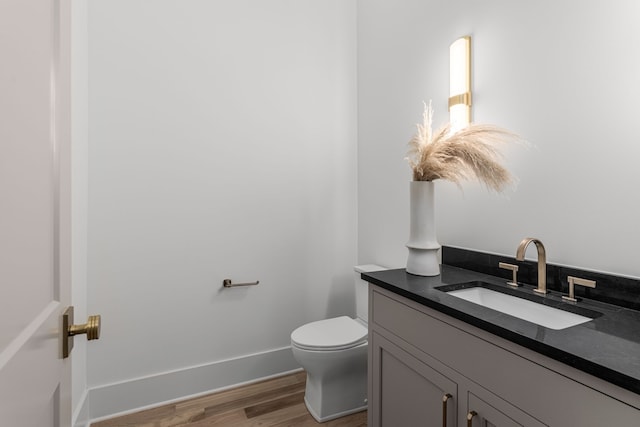 bathroom with hardwood / wood-style floors, toilet, and vanity