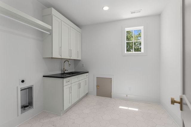 clothes washing area with electric dryer hookup, sink, and light tile flooring