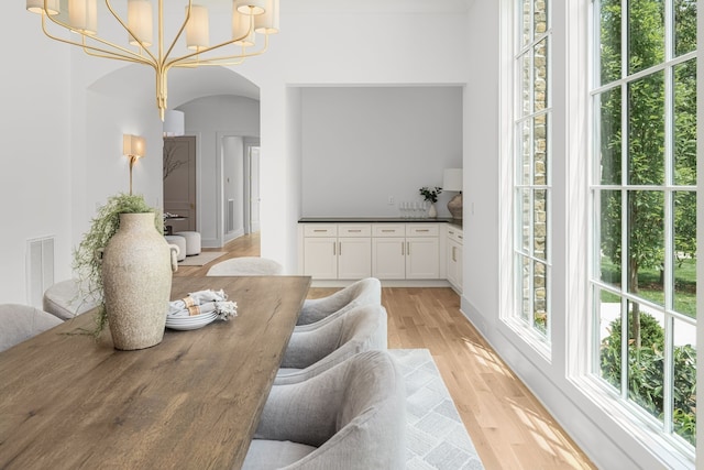 dining room with light hardwood / wood-style floors and an inviting chandelier