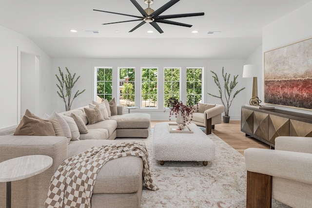 living room featuring ceiling fan, vaulted ceiling, and light hardwood / wood-style flooring