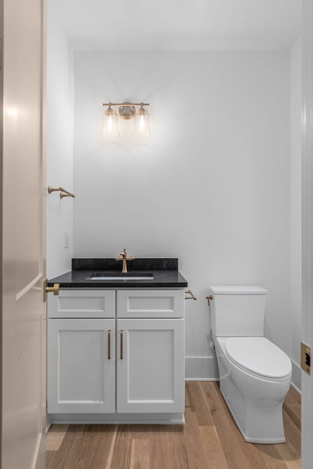 bathroom with vanity, toilet, and wood-type flooring