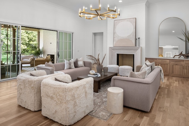 living room with a notable chandelier, light hardwood / wood-style floors, and crown molding