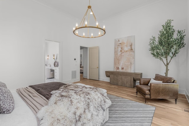 bedroom with ornamental molding, ensuite bath, hardwood / wood-style floors, a high ceiling, and a chandelier