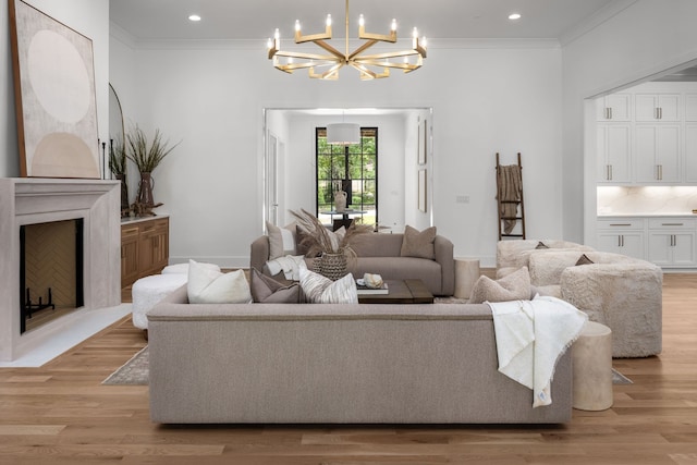 living room featuring a chandelier, light hardwood / wood-style flooring, and crown molding