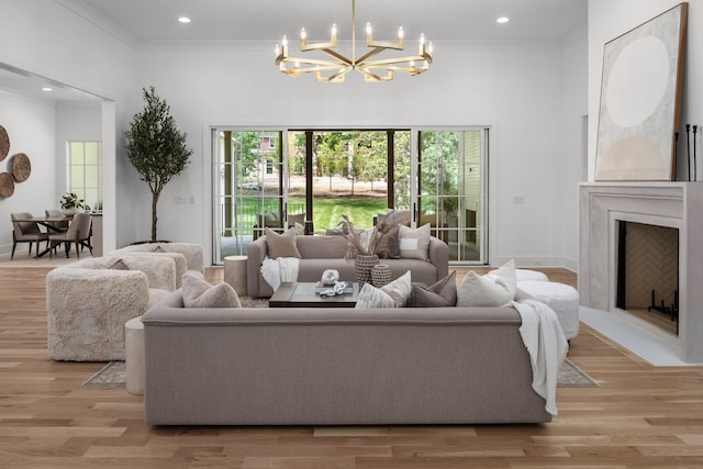 living room with crown molding, plenty of natural light, and light wood-type flooring