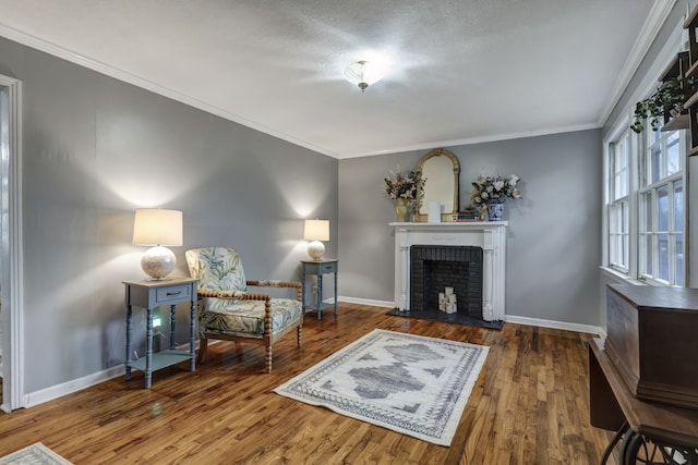 sitting room featuring crown molding, a fireplace, and wood-type flooring