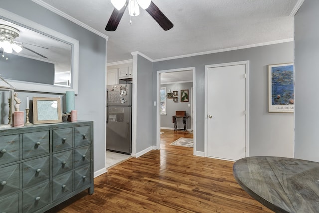 hallway with dark hardwood / wood-style floors, a textured ceiling, and crown molding