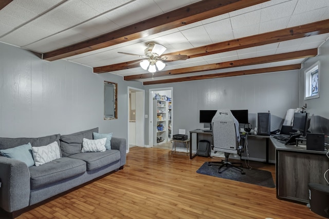 office featuring ceiling fan, light hardwood / wood-style floors, and beam ceiling