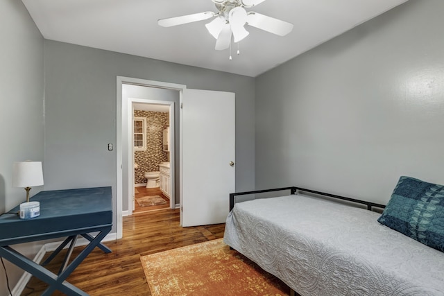 bedroom with dark hardwood / wood-style floors, ceiling fan, and ensuite bath