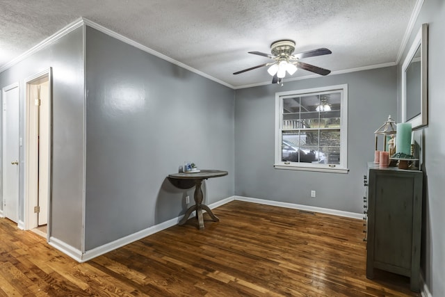 interior space with ceiling fan, ornamental molding, a textured ceiling, and dark wood-type flooring