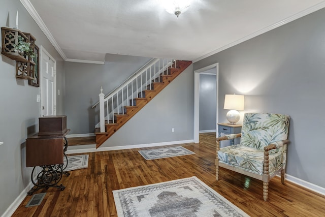 sitting room with ornamental molding and wood-type flooring