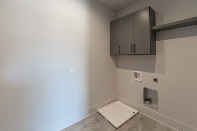 laundry room with electric dryer hookup, cabinets, light tile flooring, and hookup for a washing machine