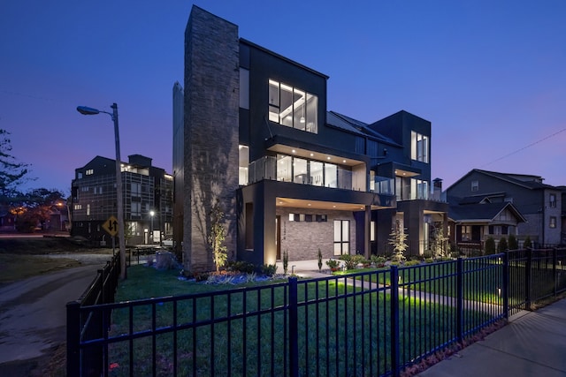 view of front of house featuring a yard and a balcony