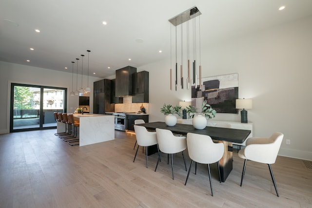 dining room featuring sink and light wood-type flooring