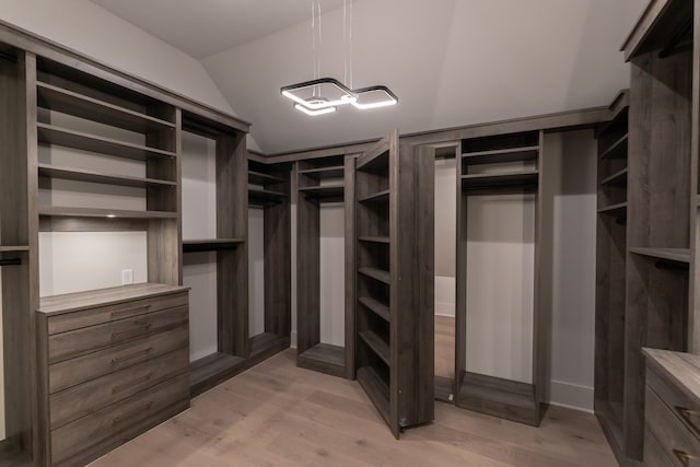 spacious closet featuring lofted ceiling and light wood-type flooring