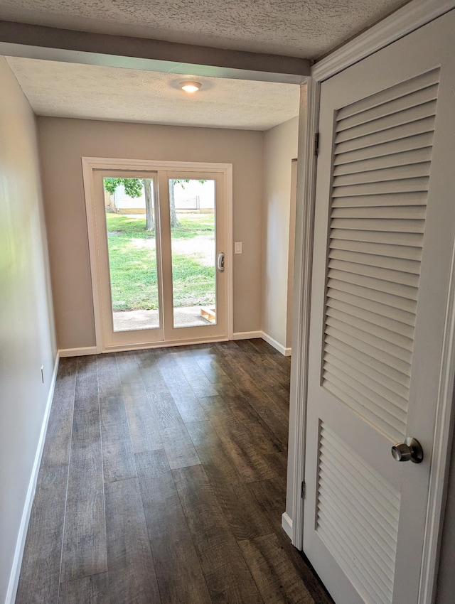 entryway with dark hardwood / wood-style flooring and a textured ceiling