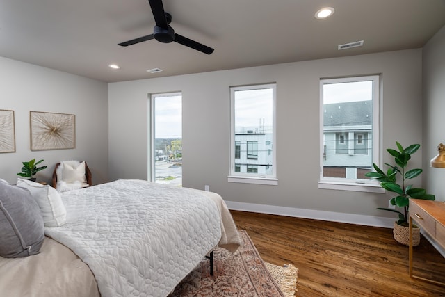 bedroom with dark wood-type flooring, ceiling fan, and multiple windows