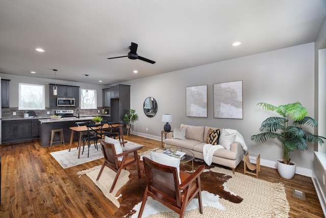 living room featuring ceiling fan, hardwood / wood-style floors, and sink