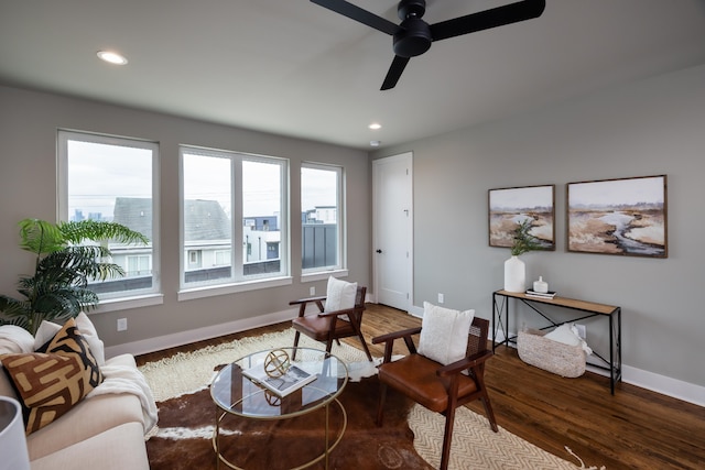 living room featuring ceiling fan and dark wood-type flooring