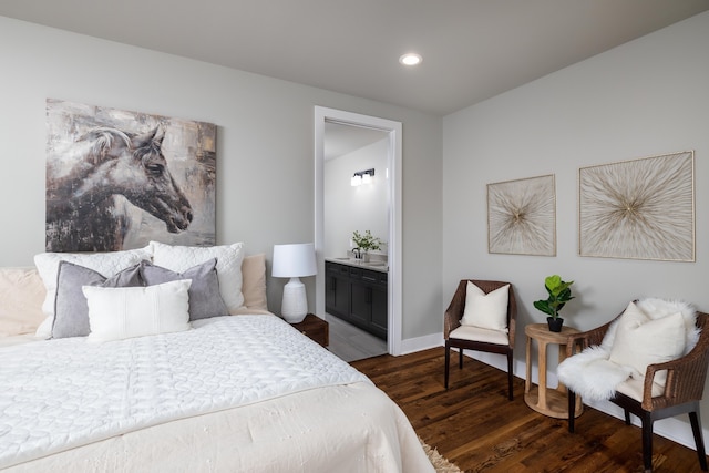 bedroom with dark wood-type flooring and connected bathroom