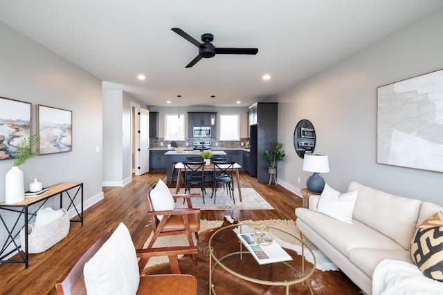 living room featuring ceiling fan and dark hardwood / wood-style floors