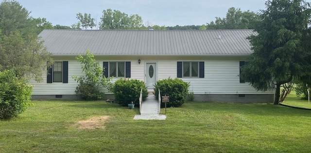 rear view of property with metal roof, a lawn, and crawl space