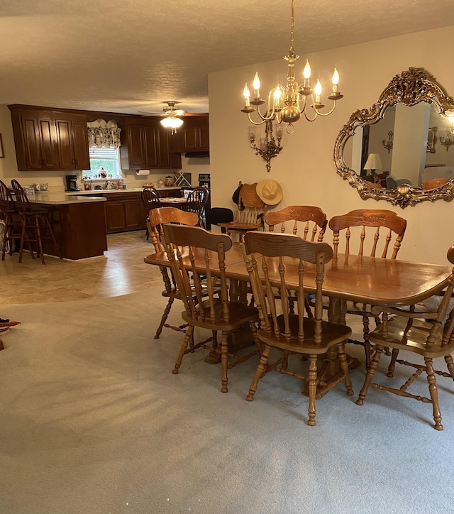 dining space with ceiling fan with notable chandelier, light carpet, a textured ceiling, and sink