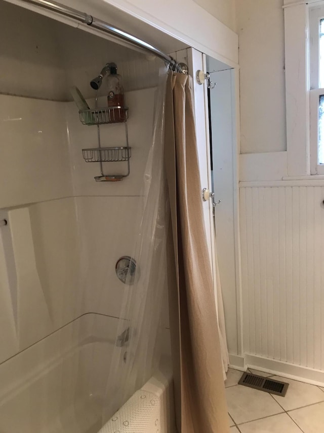 bathroom with tile floors and shower / bath combination with curtain