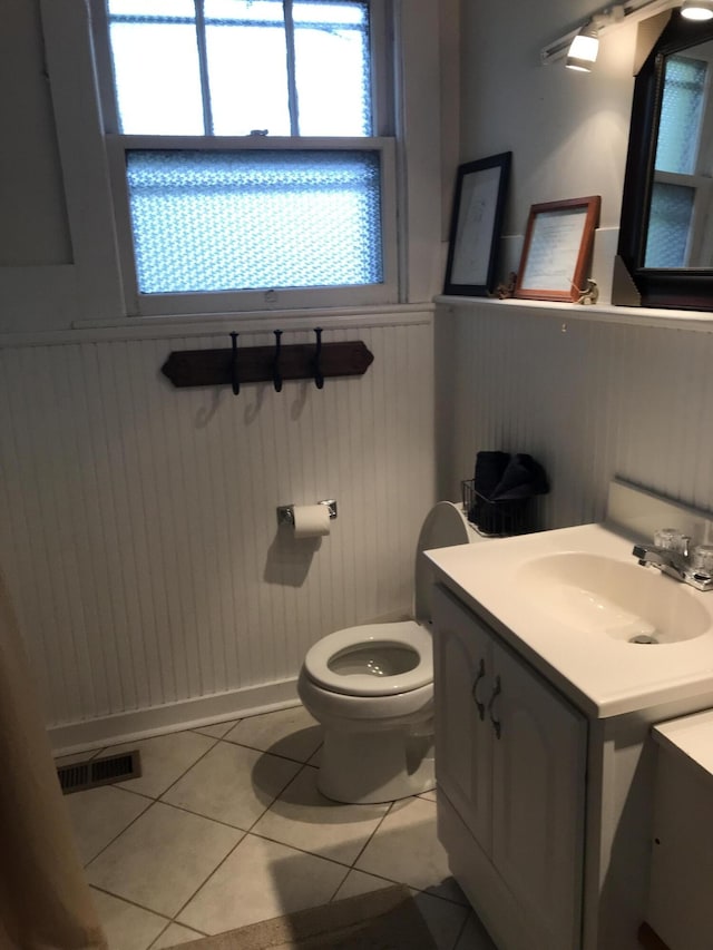 bathroom featuring tile flooring, vanity, and toilet