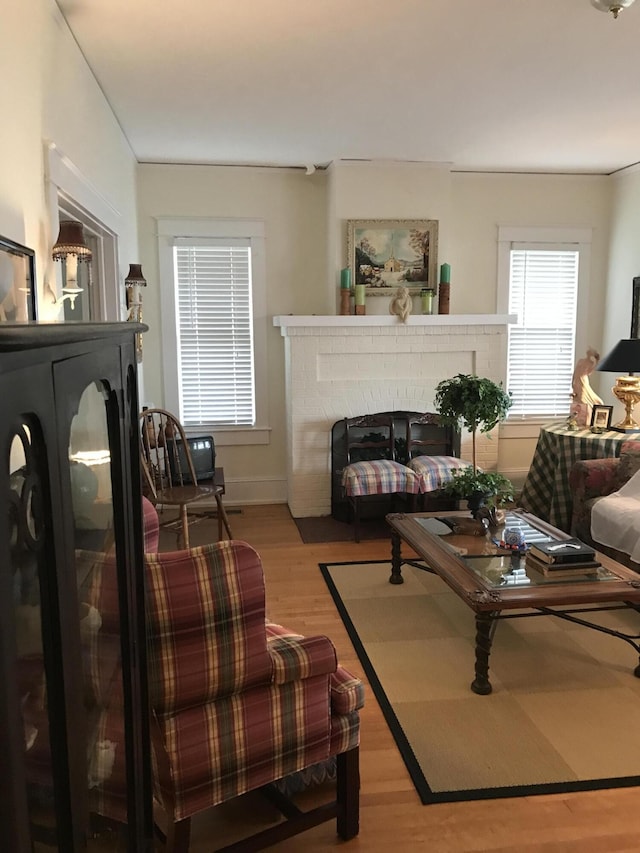 living room with hardwood / wood-style floors and a brick fireplace