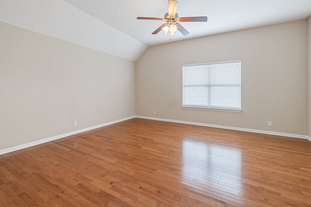 empty room featuring ceiling fan, vaulted ceiling, and light hardwood / wood-style flooring