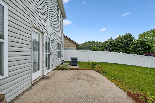 view of yard with central air condition unit and a patio area