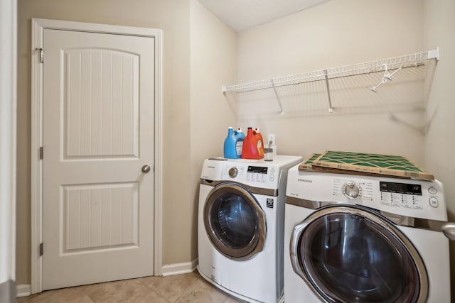 clothes washing area featuring washing machine and dryer and light tile patterned floors