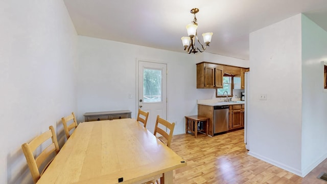 dining room featuring sink, plenty of natural light, light hardwood / wood-style floors, and a chandelier