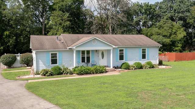 ranch-style house featuring covered porch and a front lawn