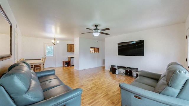 living room featuring ceiling fan with notable chandelier and light hardwood / wood-style floors