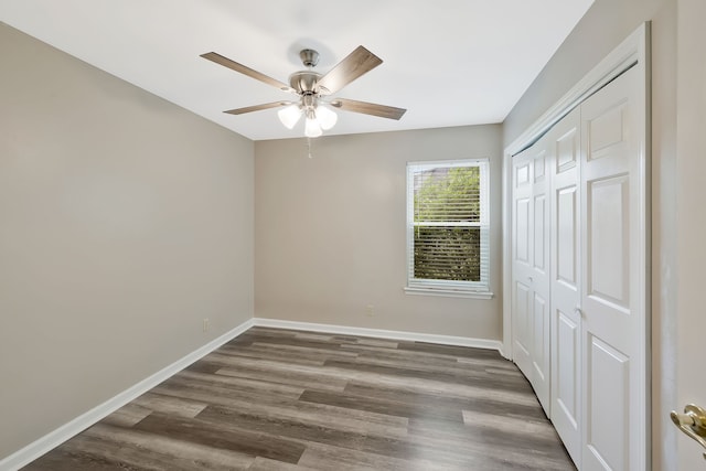 unfurnished bedroom with ceiling fan, a closet, and hardwood / wood-style flooring