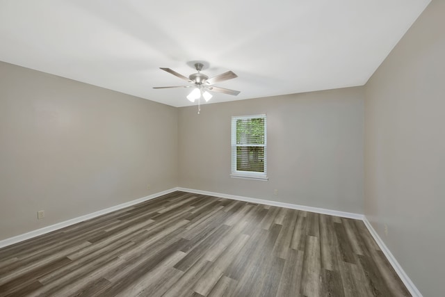 spare room with dark wood-type flooring and ceiling fan