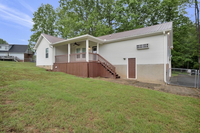 rear view of property featuring a yard and ceiling fan