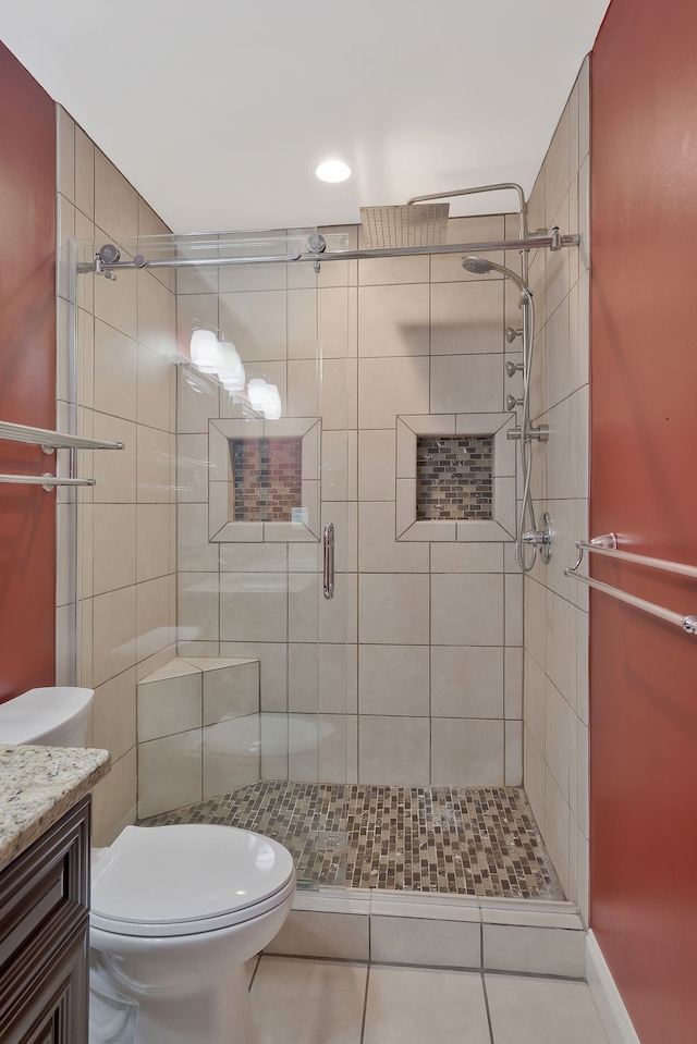 bathroom featuring tile floors, an enclosed shower, vanity, and toilet