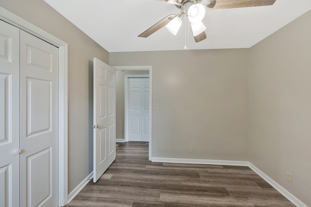 unfurnished bedroom with dark hardwood / wood-style floors, a closet, and ceiling fan