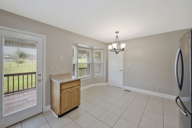 unfurnished dining area featuring a chandelier and light tile flooring